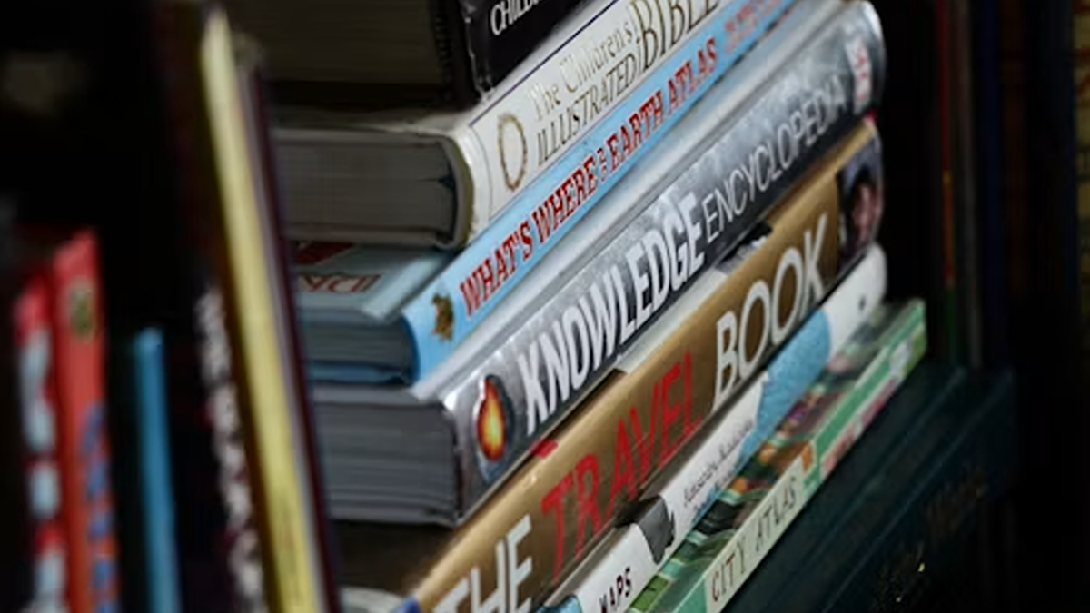 a stack of heavy hardcover books sitting on top of a shelf