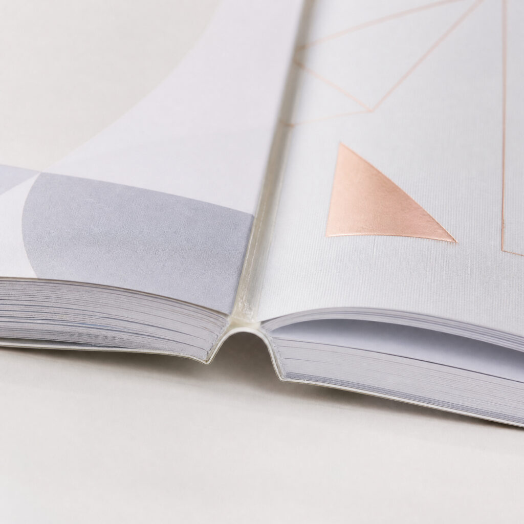 Close view of an open book at the spine hinge, with pages fanned on both sides