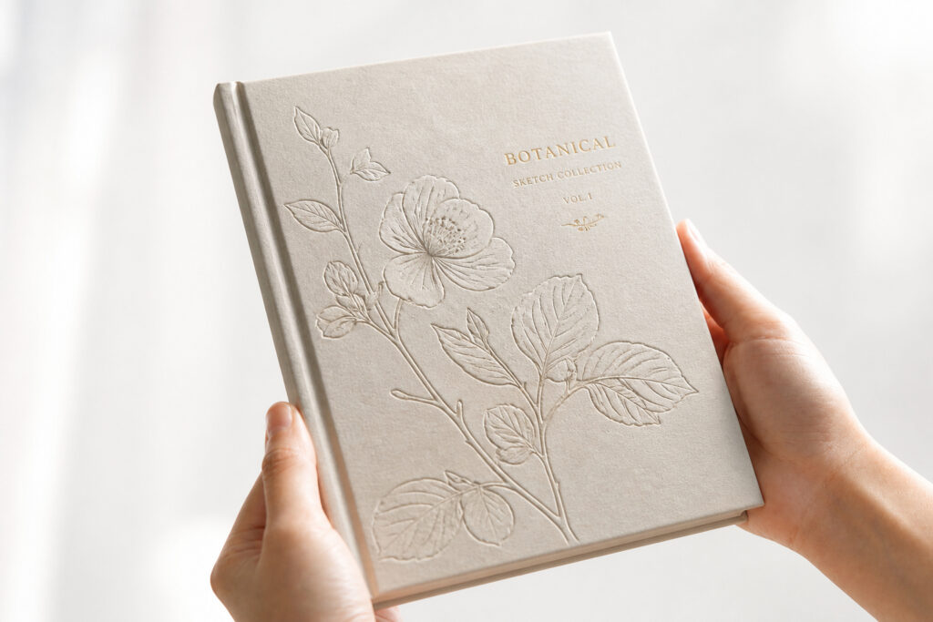 Blind embossed flowers on a pale hardcover beside a small foil title