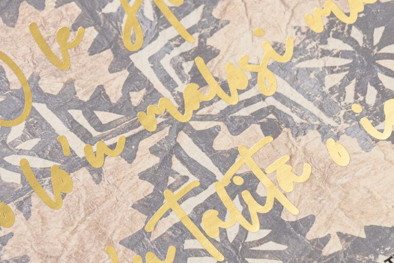 Gold foil script stamped over a printed and laminated paper cover wrap