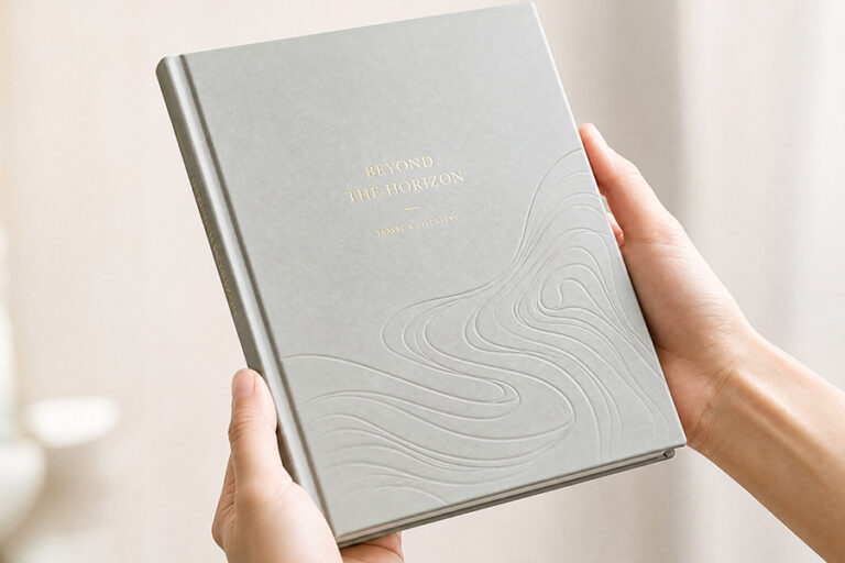 Hands holding a matte laminated cover where debossed lines catch the light